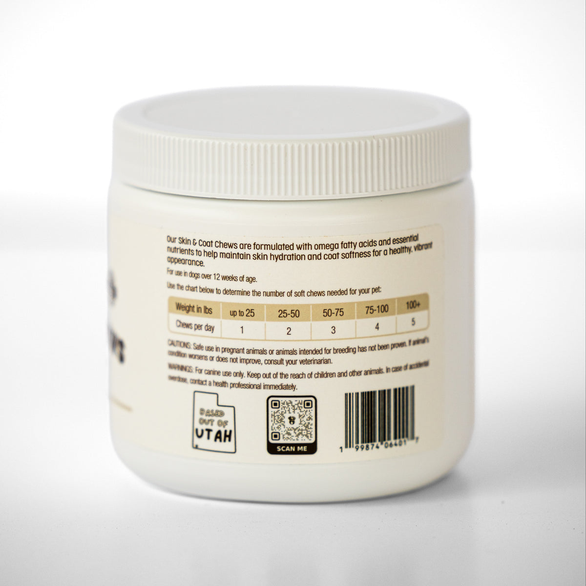 A white plastic jar of Skin & Coat Dog supplements, showing the back label with dosage, a barcode, and a QR code on a light gray background.